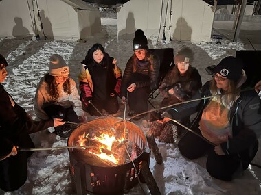 Student gathered around a campfire